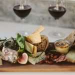 A gourmet charcuterie board paired with red wine, ideal for fine dining.
